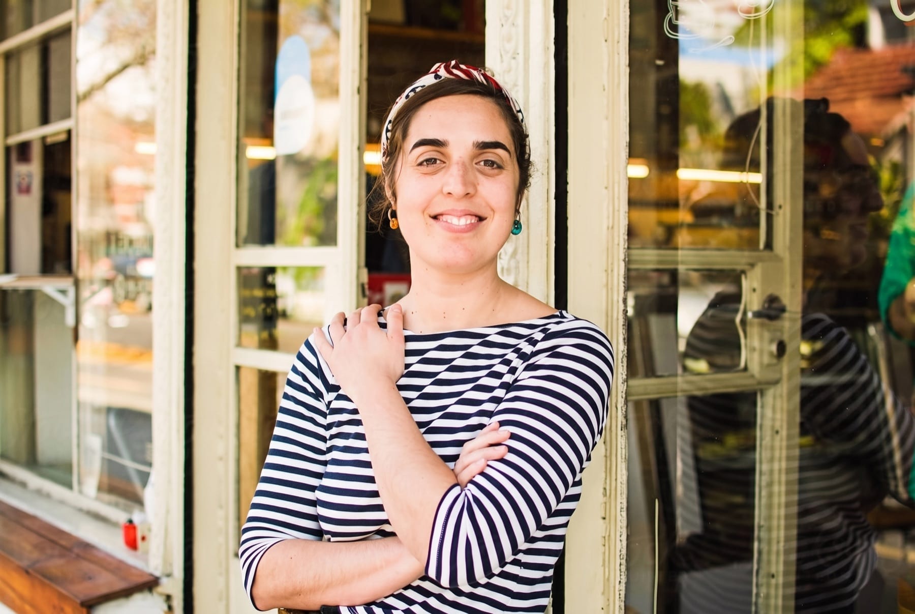 A confident woman standing in the doorway of a small business.